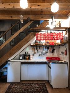 eine Küche mit weißen Geräten im Dachgeschoss in der Unterkunft Nas Kutak in Žabljak