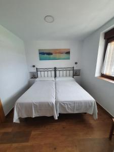 a bedroom with two beds with white sheets and a window at VADOS - LA COLINA in Arnuero