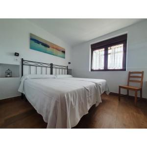 1 dormitorio con 1 cama grande y 1 silla en VADOS - LA COLINA, en Arnuero