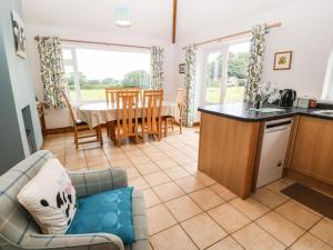 eine Küche und ein Wohnzimmer mit einem Sofa und einem Tisch in der Unterkunft Dinas Farmhouse Annex in Caernarfon