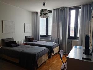 a bedroom with two beds and a desk with a computer at Terrace Apartments at Kirkkokatu in Savonlinna