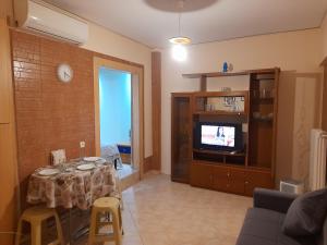 a living room with a table and a television at Cozy and comfortable in Piraeus