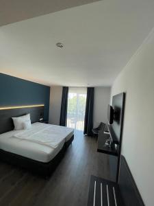 een hotelkamer met een bed en een televisie bij AiREA Hotel in Büren