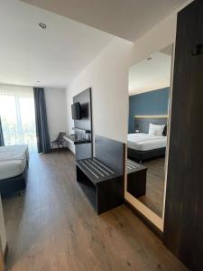 a hotel room with two beds and a mirror at AiREA Hotel in Büren