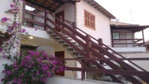 ein Gebäude mit einer Treppe mit lila Blumen darauf in der Unterkunft YOUNG (Praias de Dunas- Praia do Forte) -Aconchegante, compacto e super confortável. PRÓXIMO DE TUDO in Cabo Frio