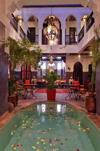 a pool in the middle of a building with flowers in it at Riad La Porte Rouge in Marrakesh