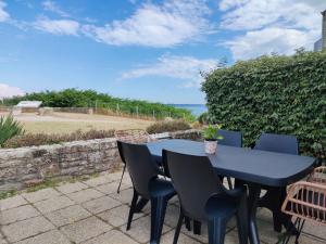 niebieski stół i krzesła na patio w obiekcie REF 047 - Bel appartement moderne pour six personnes avec vue mer plage à pied KERJOUANNO ARZON w mieście Arzon