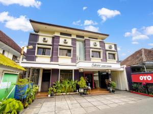 un edificio púrpura y blanco con plantas delante en OYO Collection O 91297 Hotel Sakura, en Bandung