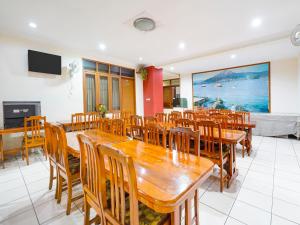 a dining room with a large wooden table and chairs at OYO Collection O 91297 Hotel Sakura in Bandung