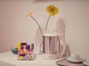 a coffee maker with a vase with a yellow flower in it at B&B Sul Corso in Salerno