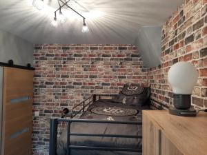 Cette chambre est dotée d'un mur en briques et d'une cuisinière. dans l'établissement GRAINES AU VENT, à Berck-sur-Mer