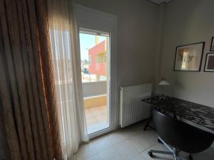 a room with a desk and a window with a view at ILION Air Host - near Athens International Airport in Markopoulo