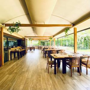 un restaurante con mesas y sillas de madera y ventanas en De Novo e d'Antico, en Cori