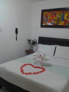 Una cama con un corazón hecho de toallas en CASA HOTEL VICTORIA Av 30, en Bogotá