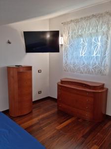 a bedroom with a bed and a dresser and a window at Casa Letizia in San Vito Chietino