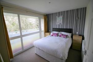 a bedroom with a bed and a large window at Atlantic Reach Cottages, Newquay 6 miles, 2 Bedrooms in Newquay