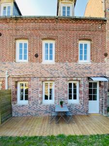 een stenen huis met een houten terras ervoor bij L'Emerald - Etretat in Étretat