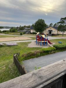 un parque infantil con equipo colorido al lado de una carretera en Källviken Semesterby en Strömstad