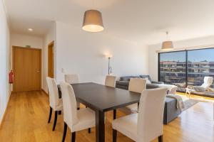 een eetkamer met een tafel, stoelen en een bank bij Jardins do Oceano in Caniço +10 foto's