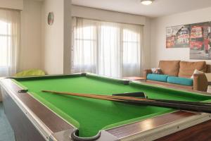 a living room with a pool table with two cuesticks at Résidence Pierre & Vacances Ty Mat in Saint Malo