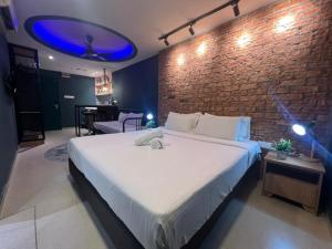 a bedroom with a large bed and a brick wall at Smile Hotel Chow Kit PWTC in Kuala Lumpur