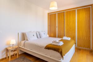 een slaapkamer met een bed met handdoeken erop bij Jardins do Oceano in Caniço