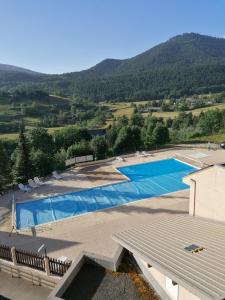 een groot zwembad met bergen op de achtergrond bij studio gresse en vercors in Gresse-en-Vercors
