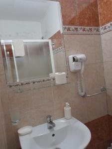 un bagno con lavandino, specchio e WC di Incantoromano guest house a Roma