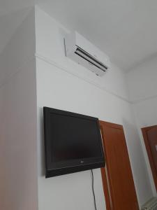 una TV a schermo piatto seduta su un muro di Incantoromano guest house a Roma