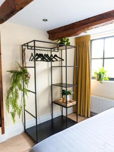 een zwarte rekken in een slaapkamer met planten bij Appartement Wolf in Alkmaar