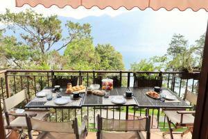 a table with food on top of a balcony at Bellagio Retreat lake view apartment in Limonta