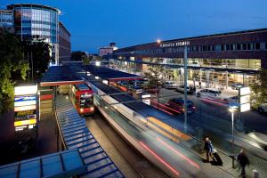 een treinstation met een trein op het spoor 's nachts bij Atlantic Hotel Airport in Bremen