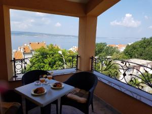 a table with two plates of food on a balcony at Residence Gordana in Selce