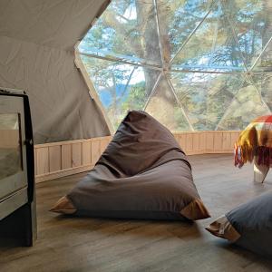 a bed in a tent with a large window at Malalcahuello Eco Glamp in Malalcahuello