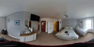 1 dormitorio grande con 2 camas y mesa en Wulfruna Hotel, en Paignton