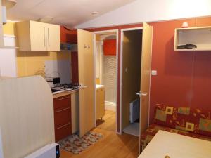 eine Küche mit orangefarbenen und weißen Wänden und einer Arbeitsplatte in der Unterkunft Vue sur mer in Mers-les-Bains