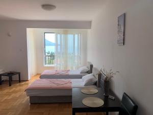 a bedroom with two beds and a table and a window at Apartment Dunja in Boreti