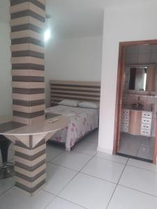 Un dormitorio con una cama y una mesa. en Hotel Dal Gobo, en Ponta Grossa