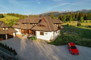 a house with a red car parked in front of it at Maciejowy Dwór in Zakopane