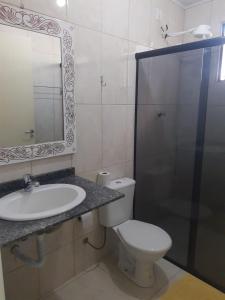 a bathroom with a sink, toilet and shower at Hotel Dal Gobo in Ponta Grossa