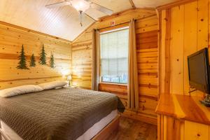 a bedroom with a bed and a flat screen tv at Drummer Boy Camping Resort in Gettysburg