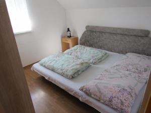 ein kleines Schlafzimmer mit einem Bett mit Blumen darauf in der Unterkunft Apartmány Bobrovnik in Liptovská Sielnica