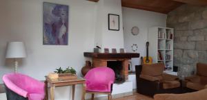 sala de estar con sillas rosas y chimenea en Dream corner by waterfalls, 20 min to Oporto, en Parada