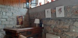 um quarto com uma parede de tijolos com uma mesa e um candeeiro em Dream corner by waterfalls, 20 min to Oporto em Parada