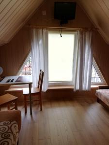 a living room with a desk and a large window at Willa Kryształ in Stegna