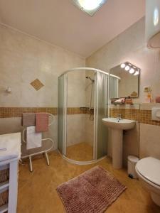 ein Badezimmer mit Dusche, Waschbecken und Toilette in der Unterkunft Hilltop Villa Risika in Risika