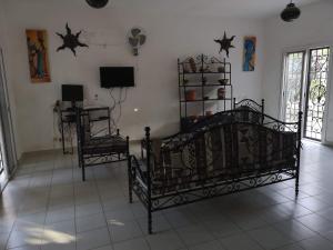 een kamer met een bed, een bureau en een televisie bij Keur Baboune in Mbour