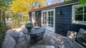 a patio with a table and chairs and a building at B&B Zilverstad Huisje De Veerpoort in Schoonhoven