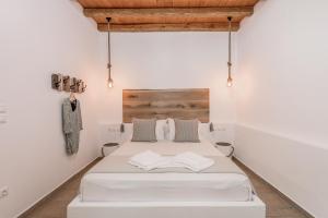 - une chambre avec un lit blanc et 2 oreillers dans l'établissement Mantelena studios & family apartments, à Pollonia
