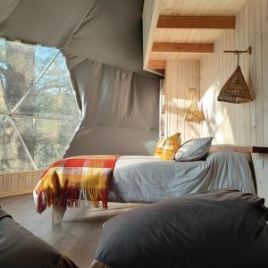 a bedroom with a bed in a tent at Malalcahuello Eco Glamp in Malalcahuello